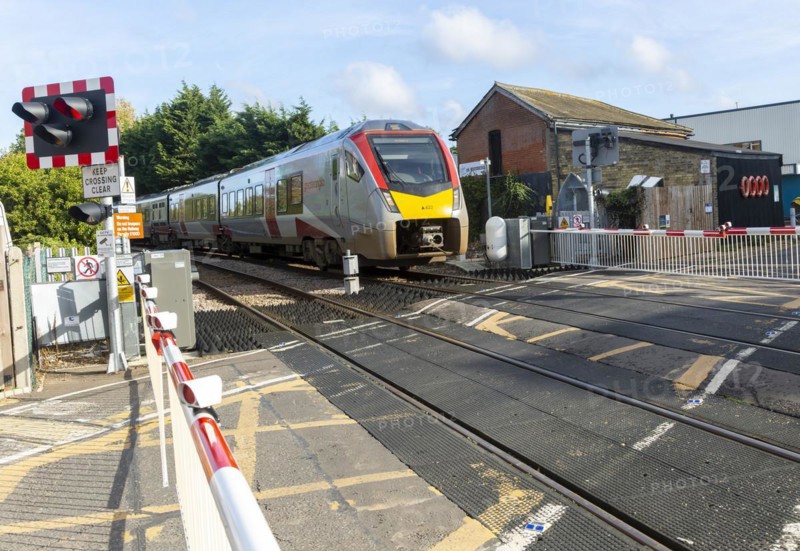 Abellio Greater Anglia Class 755 Stadler bi-modal train at level crossing