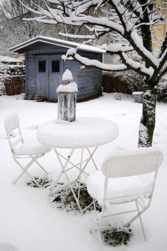 Garden table with chairs under a blanket of snow in winter