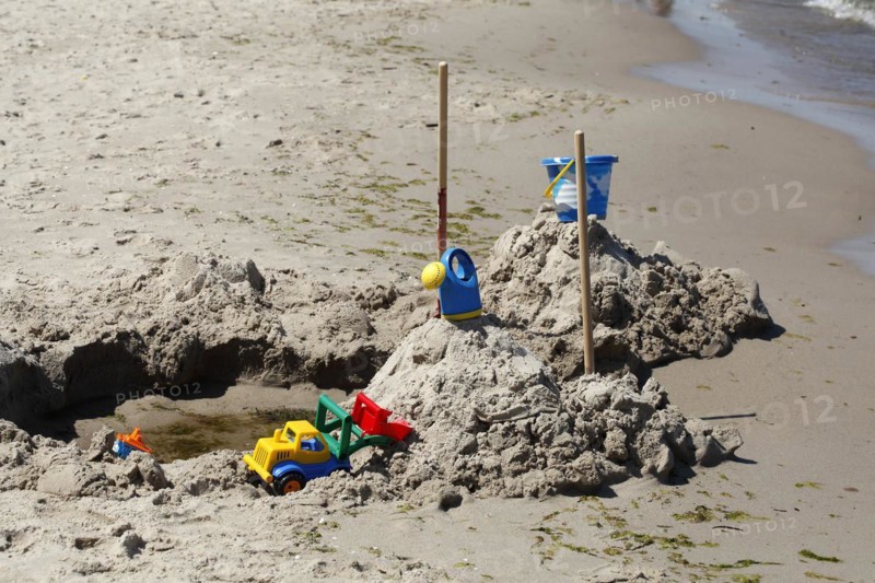 Toy and beach castle on a sandy beach by the sea