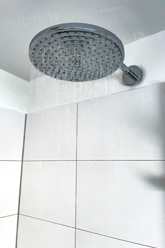 Running water from in shower with large shower head type rain shower with high water consumption