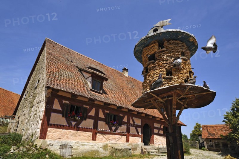 Straw-woven dovecote from 1895 behind farmhouse from 1684