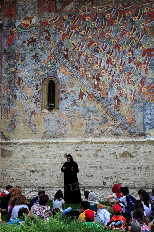 Nun explains the fresco painting Ladder to Heaven to a school class