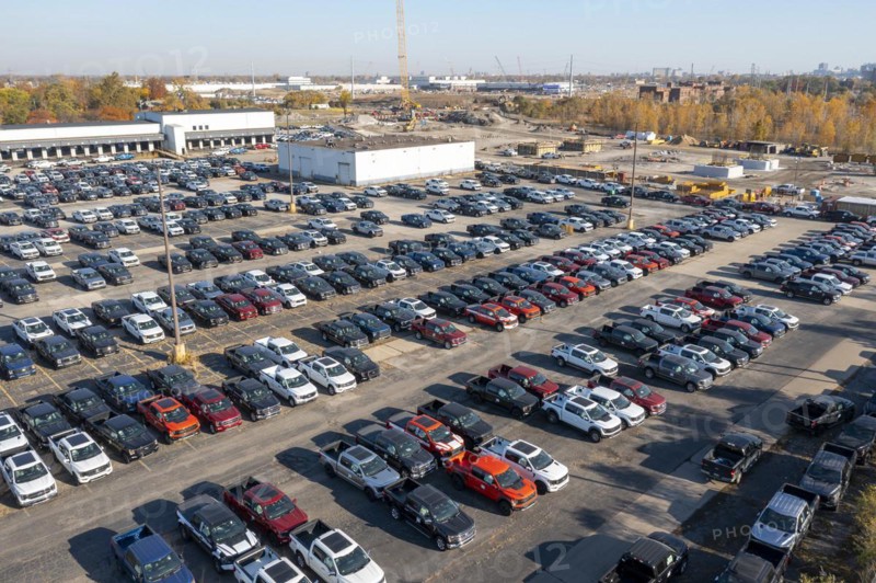 Ford pickup trucks are parked in a vacant warehouse parking lot
