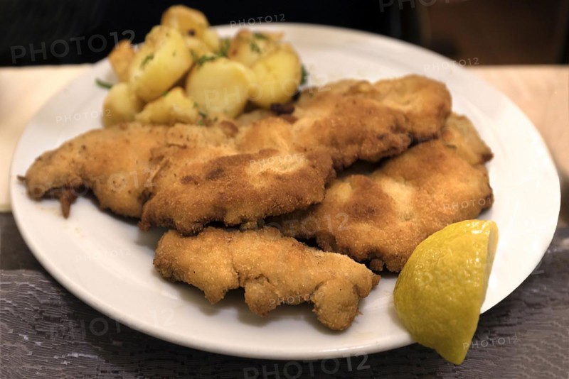 A portion of Schnitzel Viennese style with fried potatoes in a Franconian inn