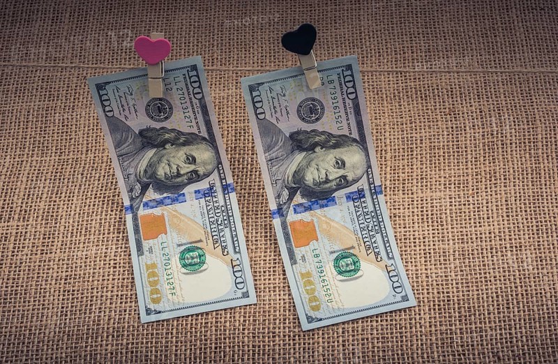 American 100 dollar banknotes with a heart clip on a string