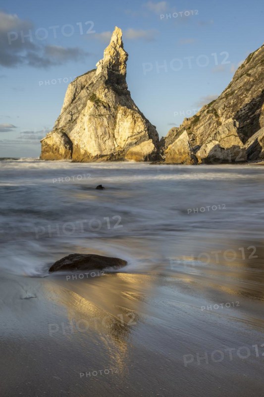 Sunset on sandy beach with rocks