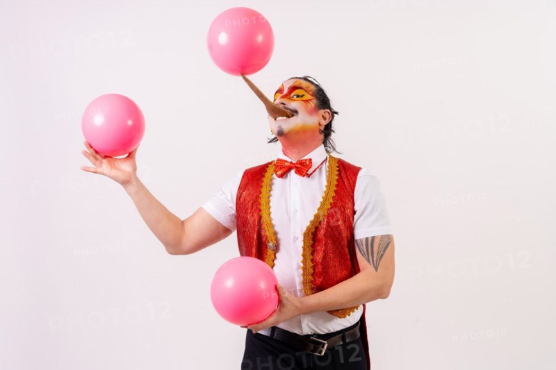 Smiling juggler juggling balls isolated on white background