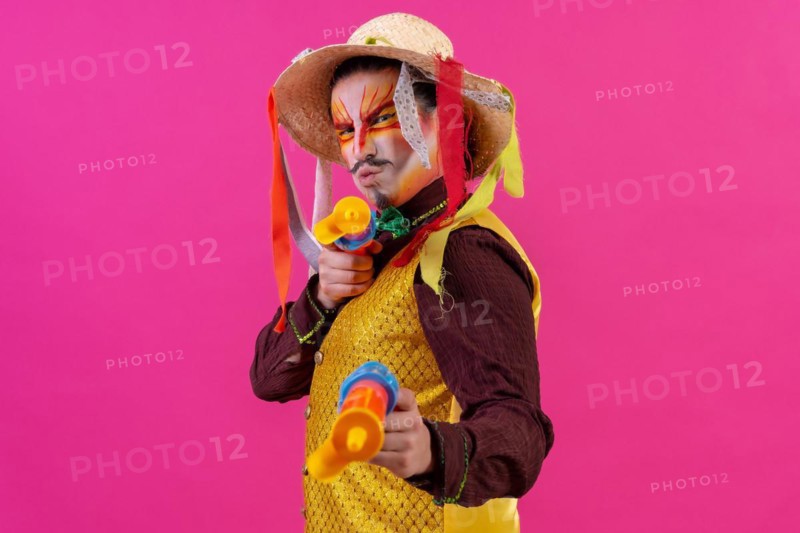 Clown with white facial makeup on a pink background
