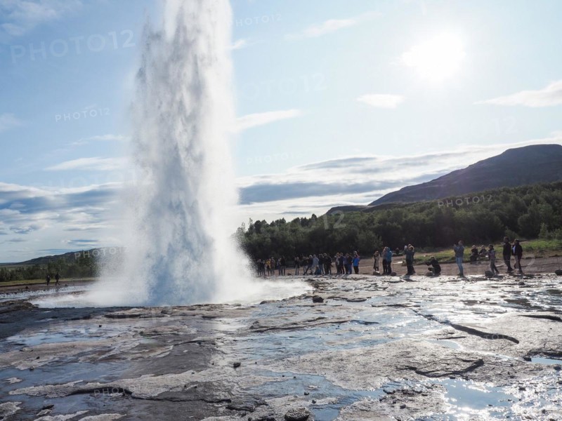 Tourists watching a geyser erupt