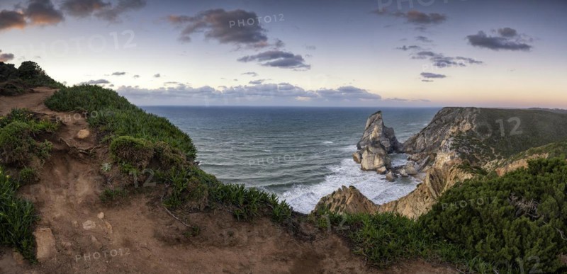 Sunset on the cliff with rocks in the sea
