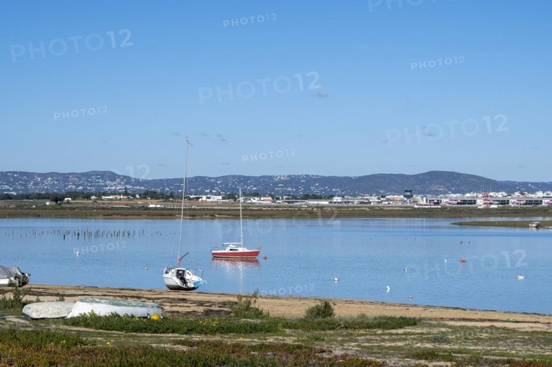 Fishing boats on the beach of the Ria Formosa nature park Park