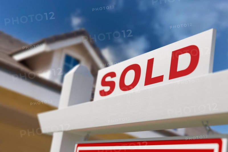 Sold for sale real estate sign in front of new house