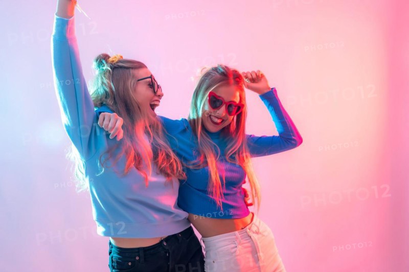 Two young blonde caucasian women dancing in disco