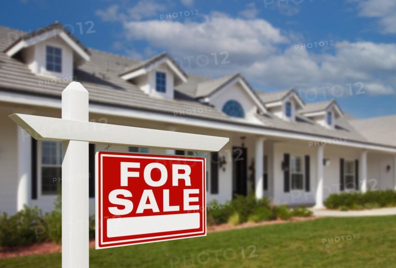 For sale real estate sign in front of new house