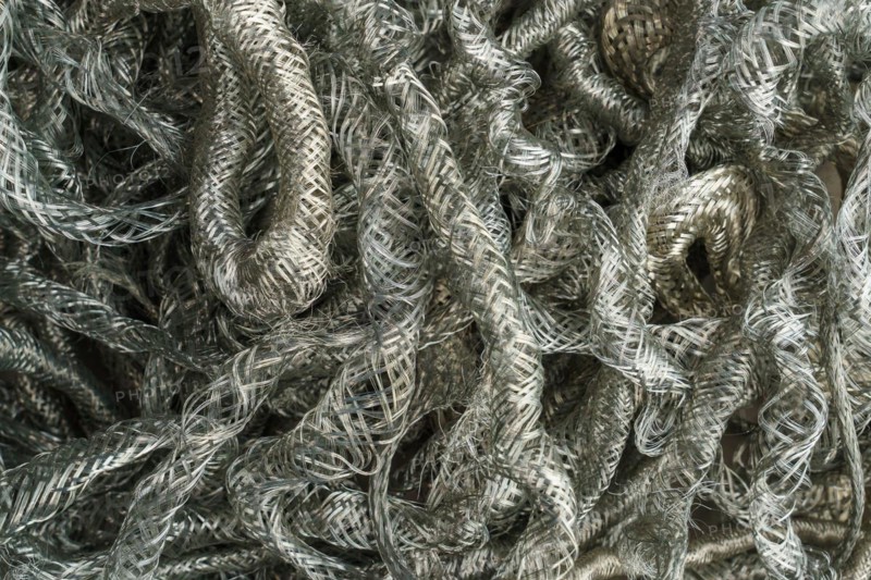 Silver metal copper wire scrap materials recycling of waste from manual wire tearing. Closeup of copper waste in the form of copper wires