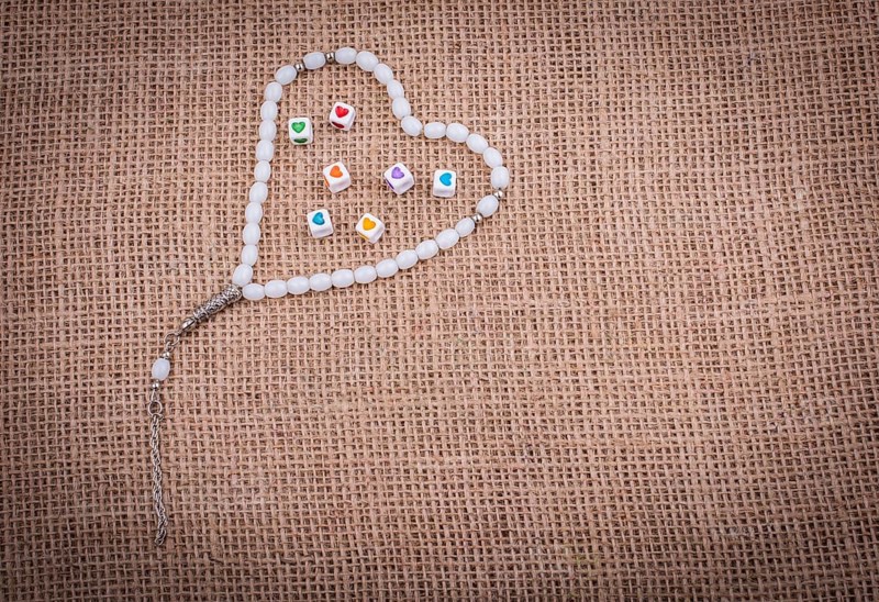 Heart shaped cubes in hand by inside a praying beads