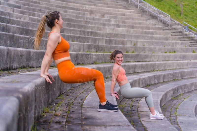 Two young fitness woman in a city park
