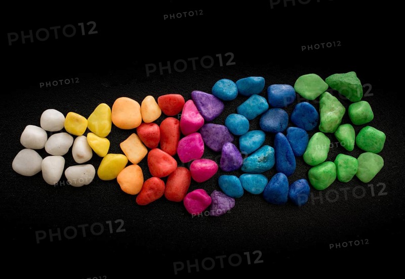 Pile of little colorful pebbles on black background