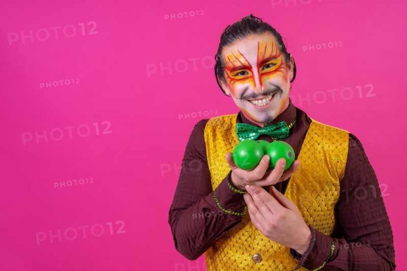 Clown with white facial makeup on a pink background