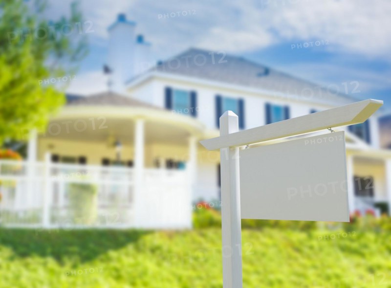 Blank real estate sign in front of new house