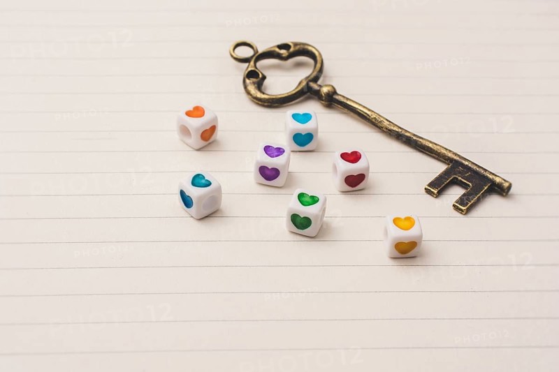 Key and colorful cubes with a heart placed on paper