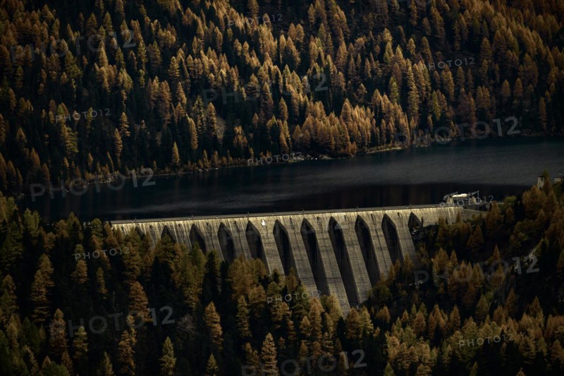 Dam of the Zufrittsee with autumnal mountain forest