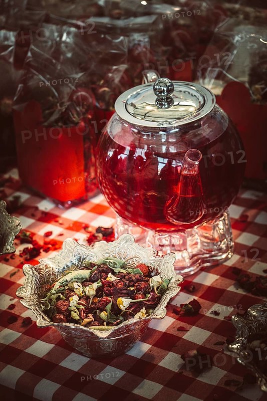 Herbal tea in glass teapot on table