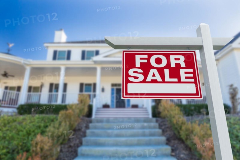 For sale real estate sign in front of new house