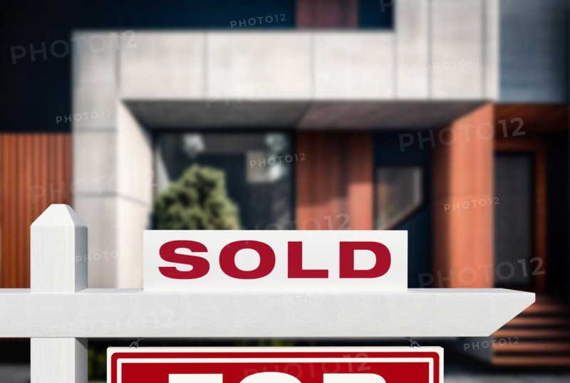 Sold real estate sign in front of new contemporary house