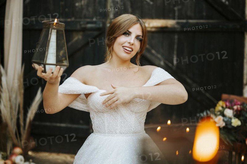 Portrait of beautiful bride holding lantern in rustic background