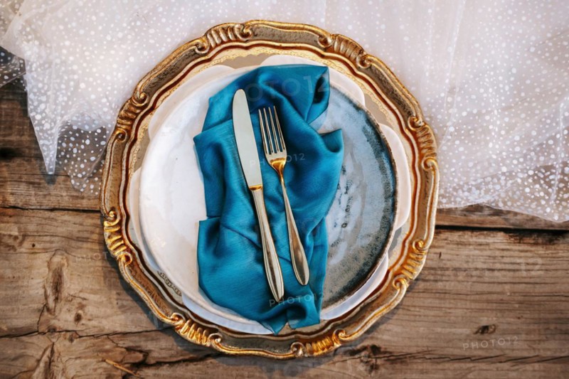 Golden and blue elegant table set on wedding dress