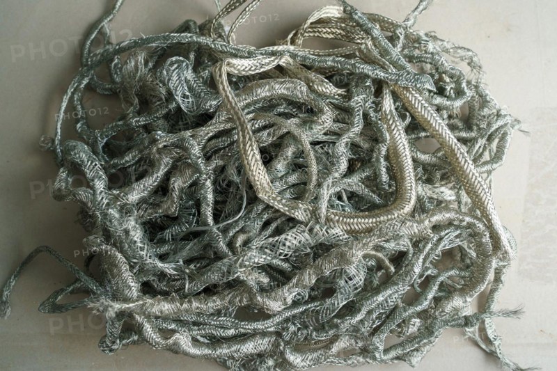 Silver metal copper wire scrap materials recycling of waste from manual wire tearing. Closeup of copper waste in the form of copper wires