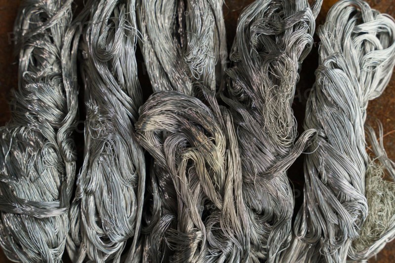 Silver metal copper wire scrap materials recycling of waste from manual wire tearing. Closeup of copper waste in the form of copper wires