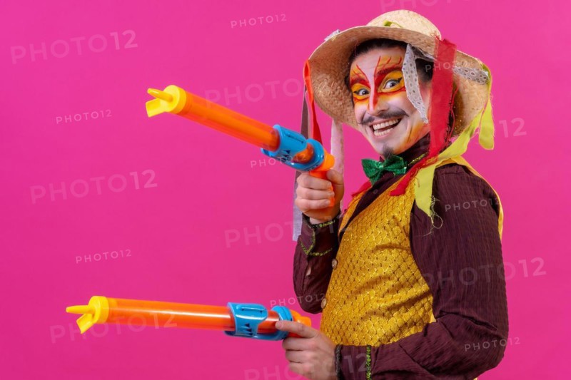 Clown with white facial makeup on a pink background