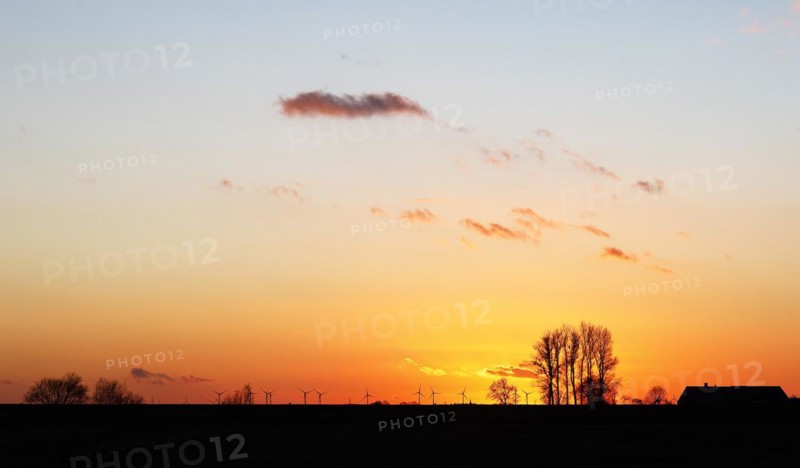 Dramatic evening sky with sunset over the Elbe dike near Faehrmannssand