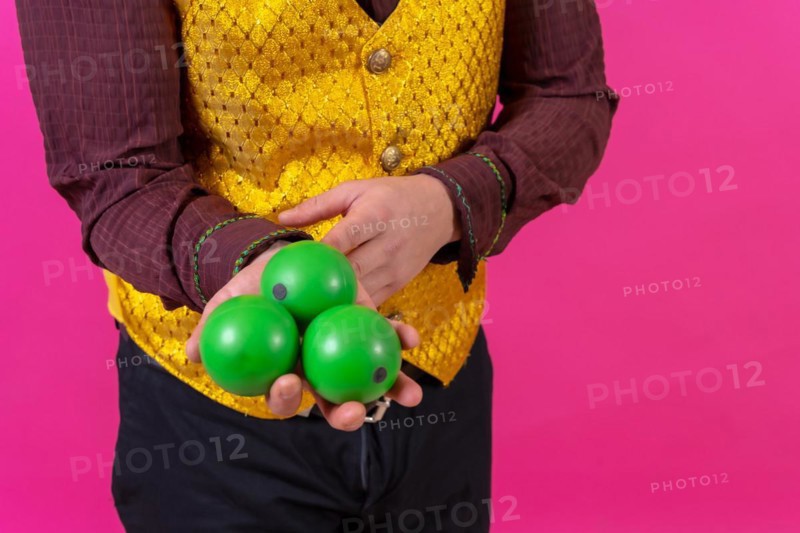 Portrait of clown with white facial makeup on a pink background