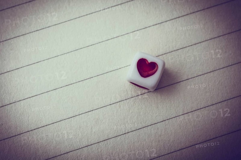 Colorful cube with a heart placed on paper