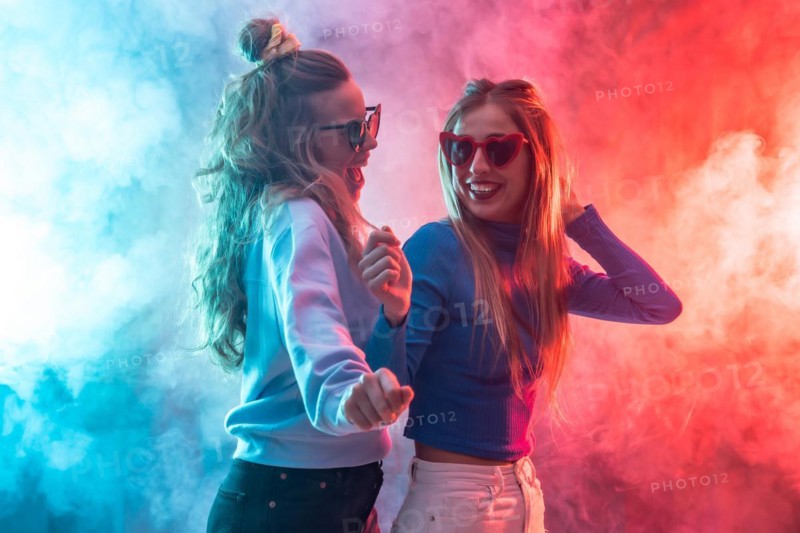 Two young blonde caucasian women dancing in nightclub