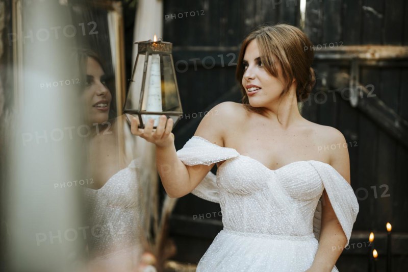 Portrait of beautiful bride holding lantern in rustic background