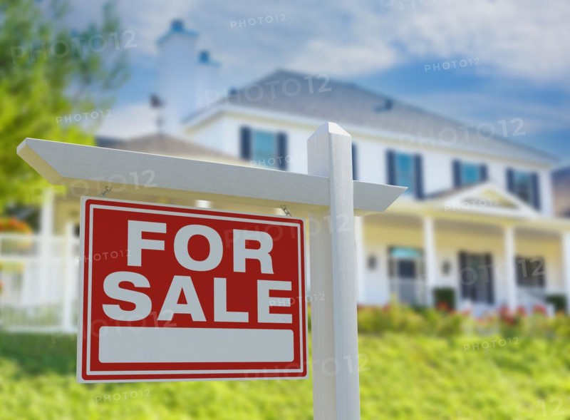 For sale real estate sign in front of new house