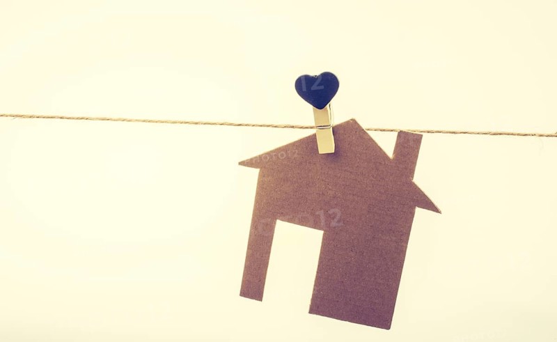 Little paper house attached to a string with a heart clip