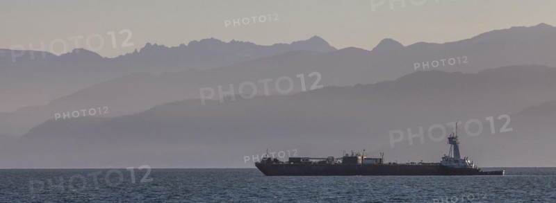A cargo ship passes the Spit near Homer