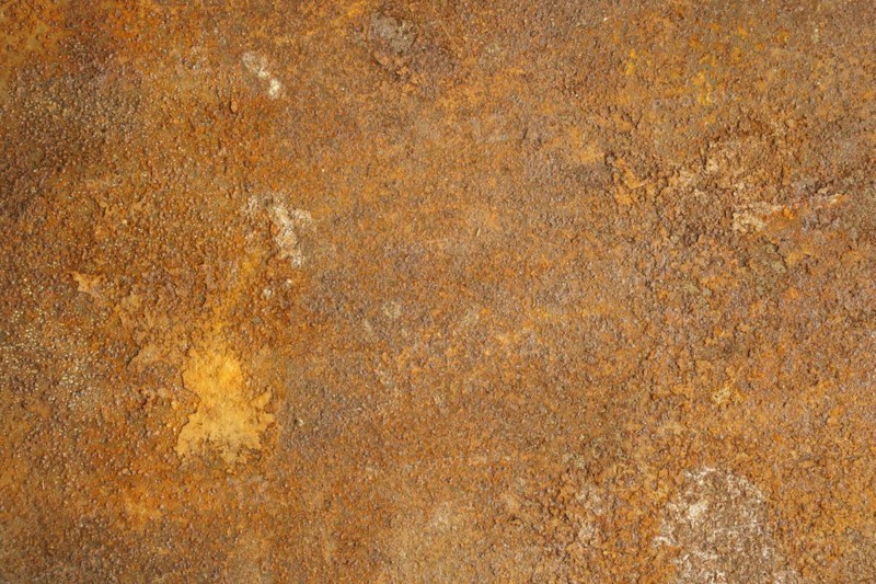 Textured metal surface with detailed traces of corrosion and rust