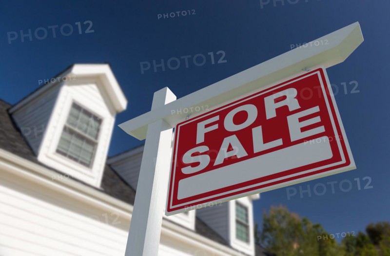 For sale real estate sign in front of new house