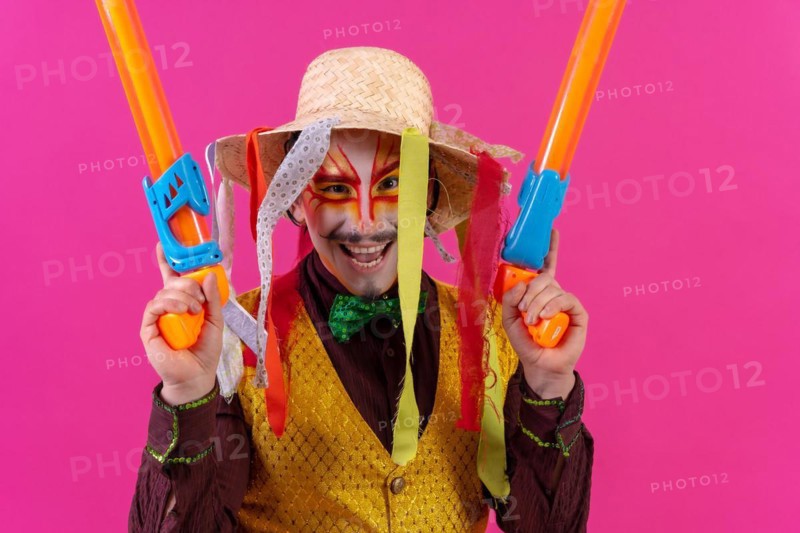 Clown with white facial makeup on a pink background