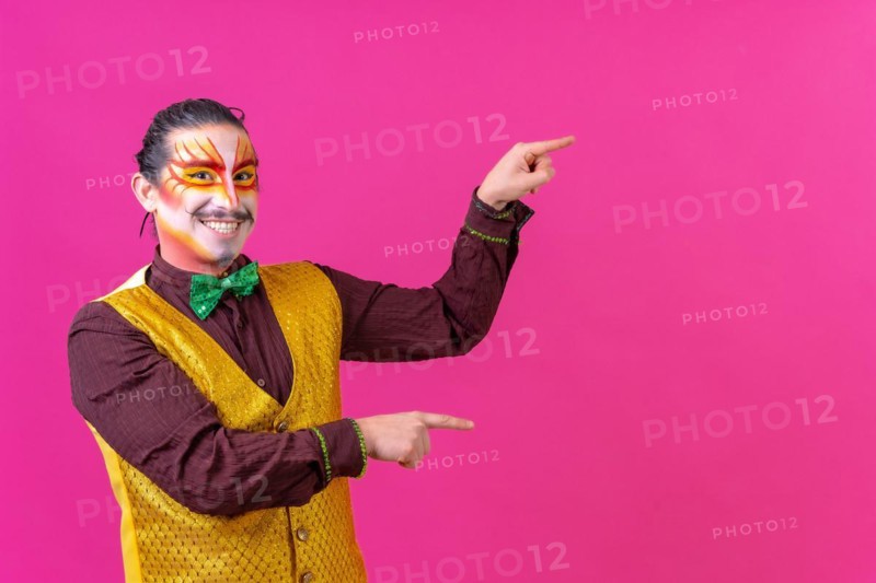 Clown with white facial makeup showing an empty space from the pink background