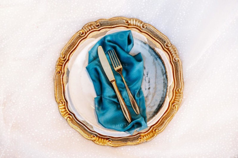 Golden and blue elegant table set on wedding dress