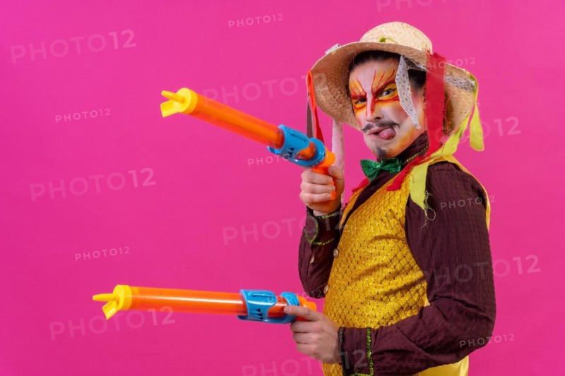 Clown with white facial makeup on a pink background