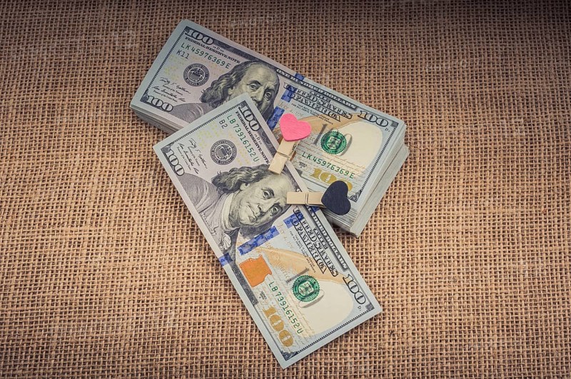 Heart icon bundle of US dollar placed on a linen canvas