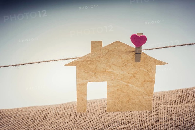 Little paper house attached to a string with a heart clip